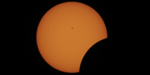 A partial solar eclipse, with the moon partially covering the sun.